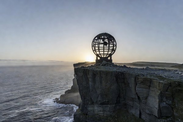 The iconic iron globe monument standing on the 307-meter cliff edge of North Cape